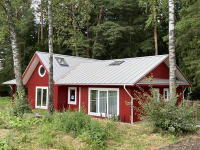 Одноэтажный загородный дом в окружении деревьев